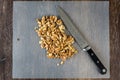 ChefÃ¢â¬â¢s knife and a pile of raw walnuts on a plastic cutting mat, ready for baking Royalty Free Stock Photo